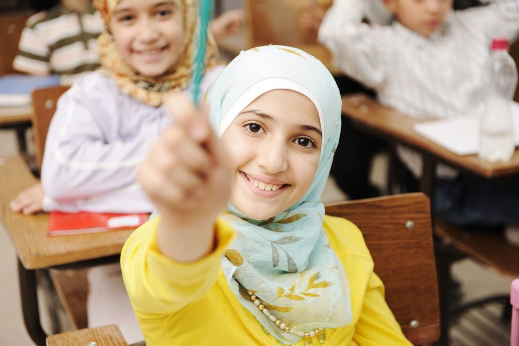 Lachende leerling met een potlood in de klas